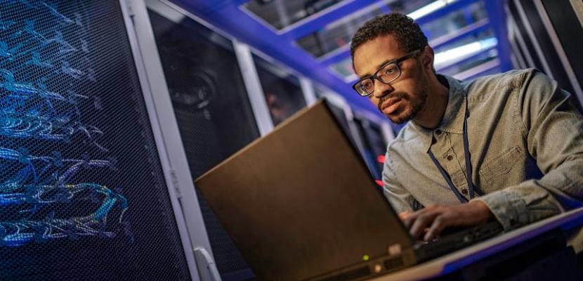 Man using laptop in a server room