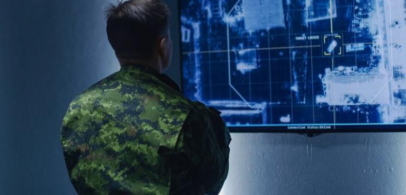 Man in military unifrom looking at a monitor