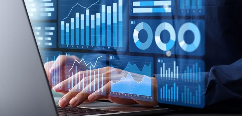Hands typing on a laptop with an overlay of various types of charts.